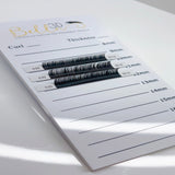 Bella 3D Acrylic Lash Tile displaying various curled and thick eyelash extensions for professional use.
