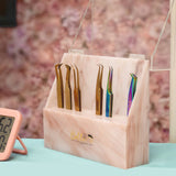 Acrylic Tweezer Stand holding six eyelash extension tweezers in metallic and rainbow finishes on a pink marble base.