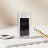 Cashmere Matte Easy Fan Lashes - 0.05 in black with gold tweezers and eyelash extensions on white surface