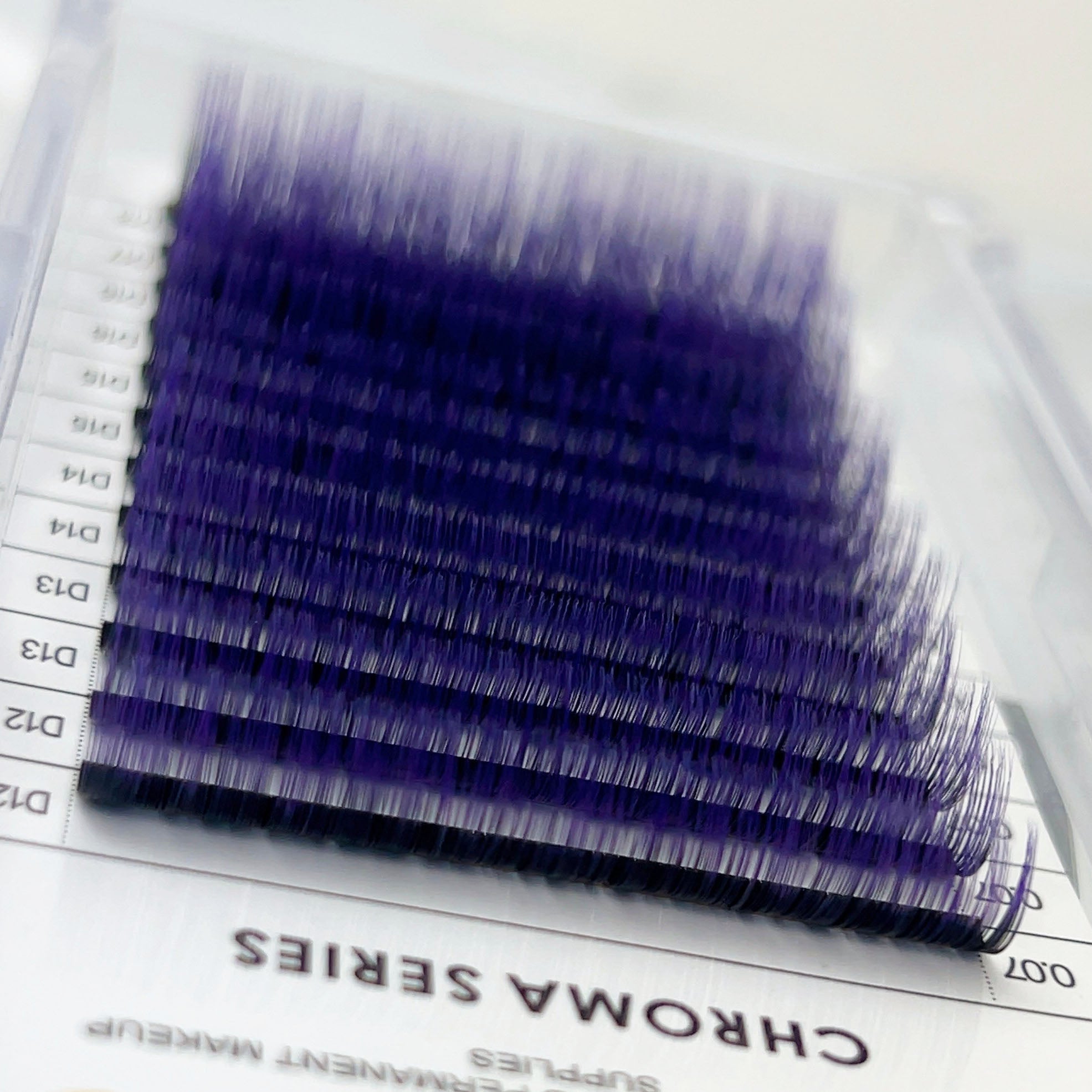 Chroma Ombré - 0.07 eyelash extensions in purple ombré shades arranged in a layered tray display.