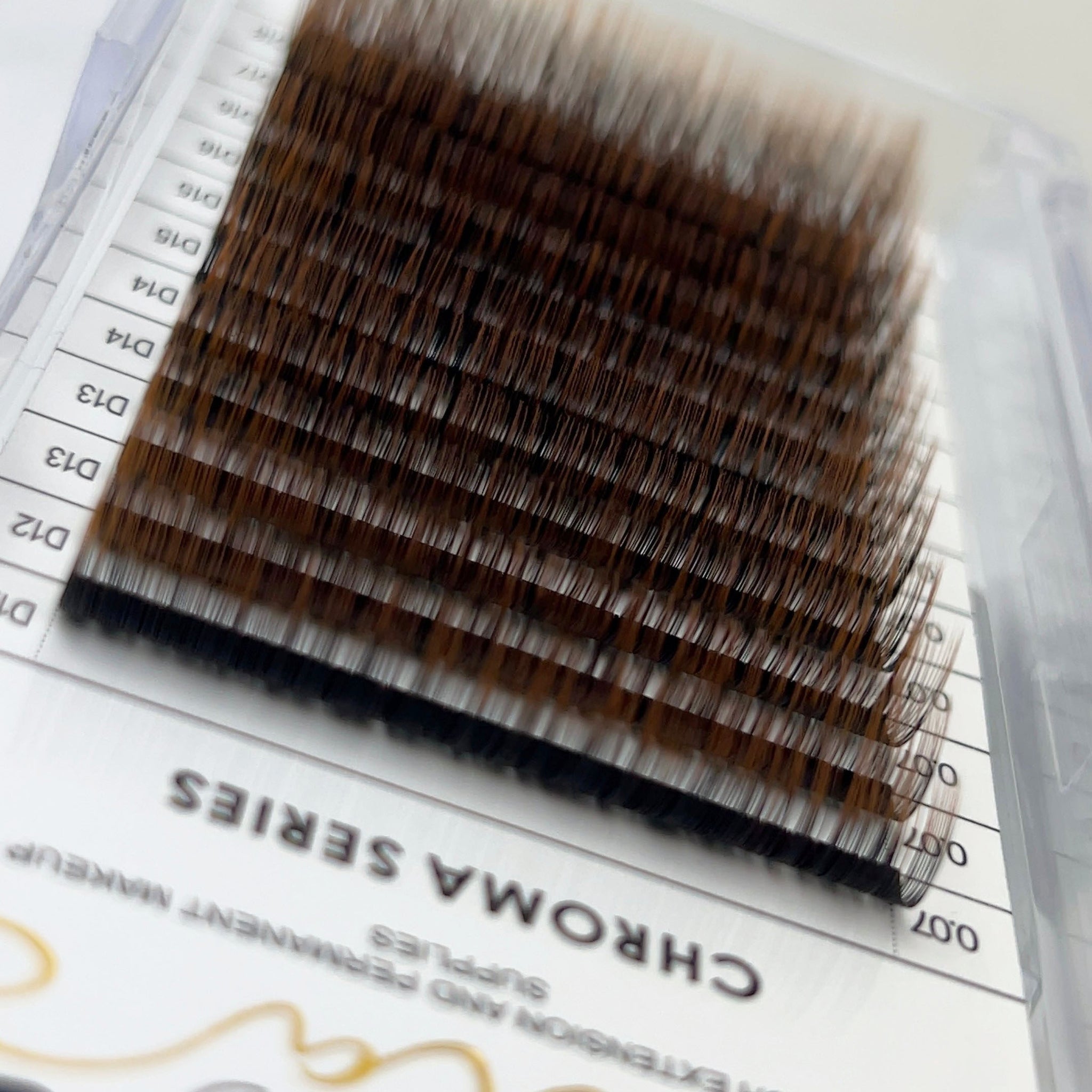 Tray of Chroma Ombré - 0.07 eyelash extensions with a gradient from dark to light brown shades.