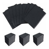 Black disposable Dental Bibs arranged fanned out and stacked in three neat piles on a white background