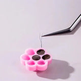 Honey Cups! Self-Adhering Glue Cups holding eyelash extension adhesive with tweezers applying individual lashes