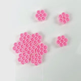 Honey Cups! Self-Adhering Glue Cups in pink, arranged in flower-shaped clusters for eyelash extension adhesive use