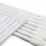 Close-up of white Lip Wands with soft foam tips used for precise application in beauty and eyelash extension supplies.