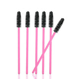 Six pink handled mascara wands with black bristles arranged upright with one wand angled to the side, Mascara Wands
