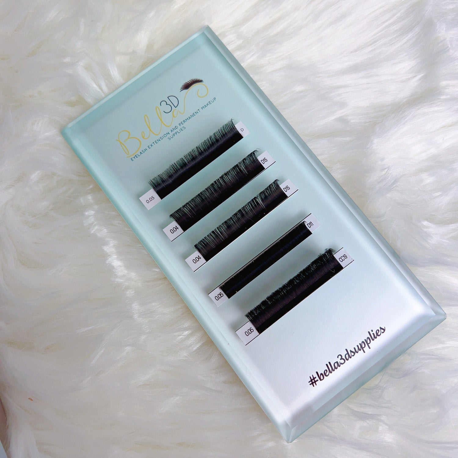 Ombré Lash Tile with multiple rows of varying lengths of eyelash extensions on a light blue tray for professional use