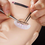 Practice Mannequin Head used for detailed eyelash extension training with tools applying individual lashes carefully