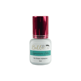 Small white bottle of Signature Elite No Shake Adhesive eyelash extension glue with metallic red cap and teal label.