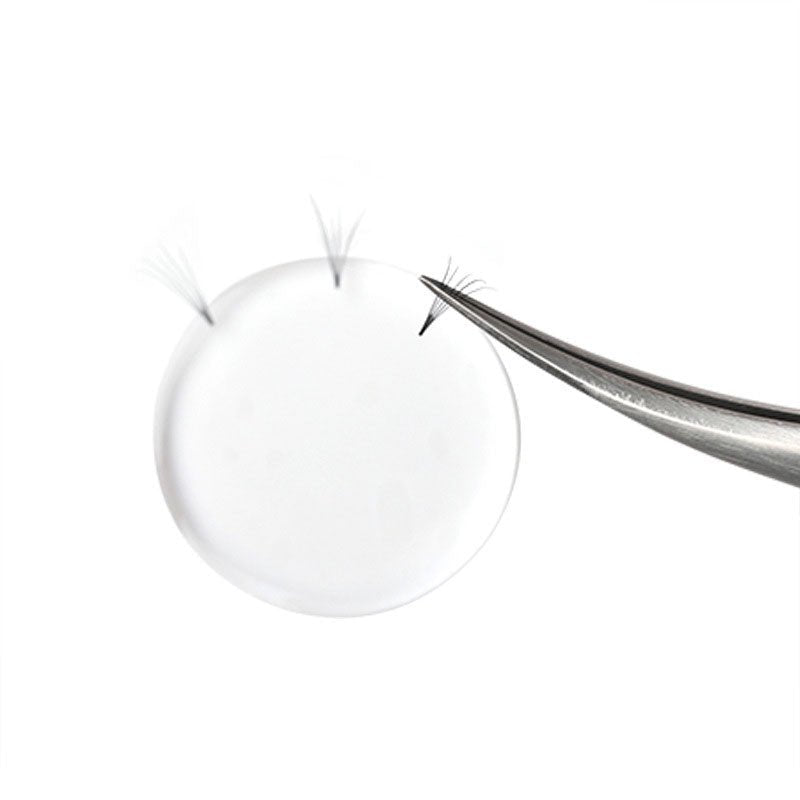Silicone Lash Pad with tweezers holding eyelash extensions used for eyelash extension accessories and adhesive application