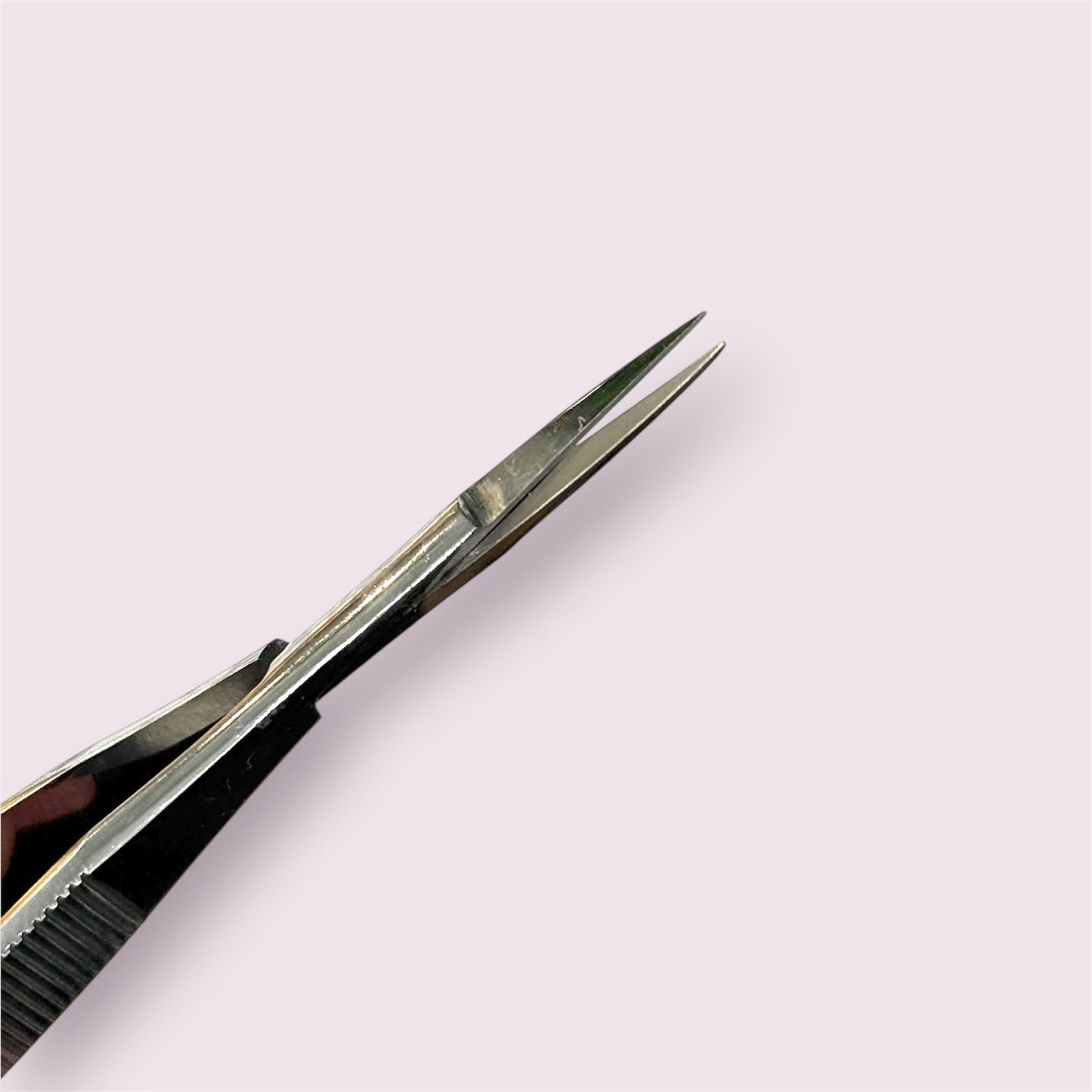 Close-up of stainless steel Straight Spring Scissors with pointed tips on a pale background