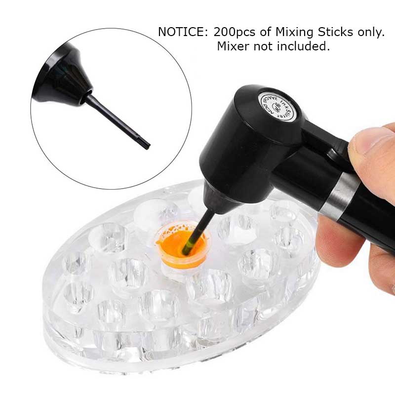 Hand holding a black motorized device using tattoo mixing sticks to mix orange pigment in a clear palette tray.