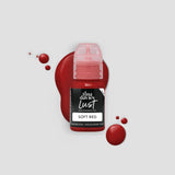 Bottle of Tina Davies Lust Soft Red lip pigment with red paint splashes on a light gray background